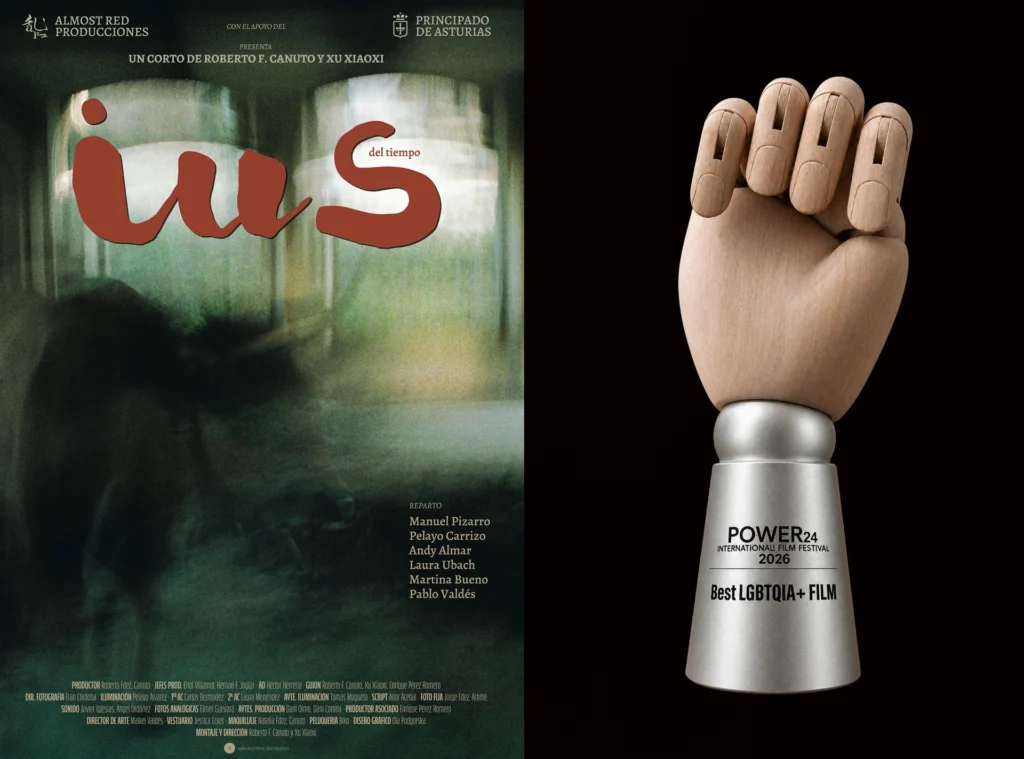 Cartel del cortometraje asturiano IUS del tiempo junto a su premio del Power24 a la Mejor Película LGBTQIA+, un trofeo sobre una mano de madera de artista.
