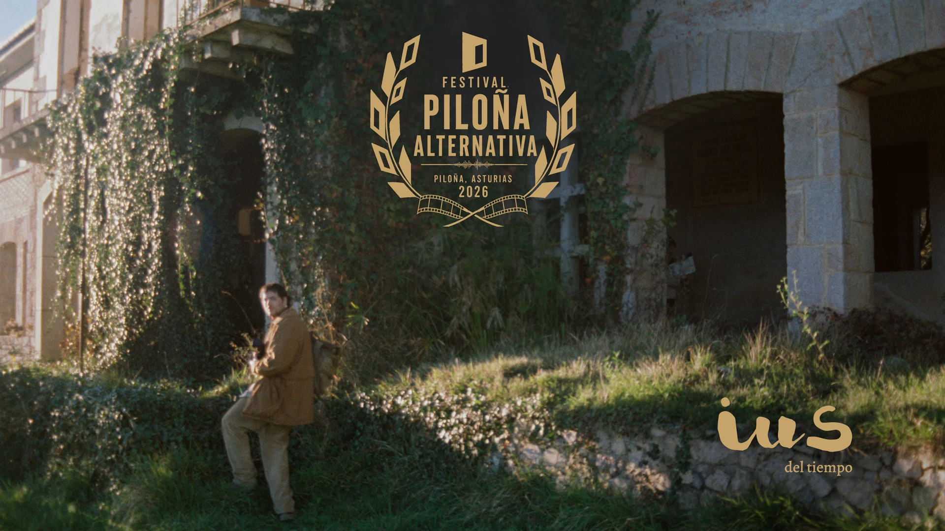 Behind the scenes of IUS of Time: analogue photograph by Elmer Guevara of Luca (Pelayo Carrizo) outside the former Cándido San Miguel school in Piloña, with the Festival Piloña Alternativa laurel