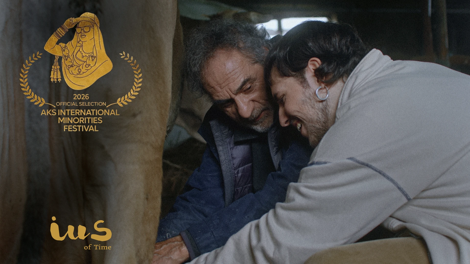 Scene from IUS of Time featuring its two protagonists and the official selection laurel for AKS International Minorities Festival 2026.